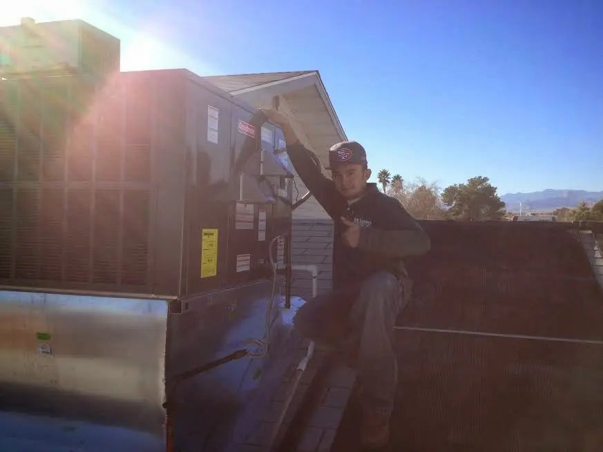 HVAC technician performing Air Duct Cleaning on a rooftop unit in Somerdale